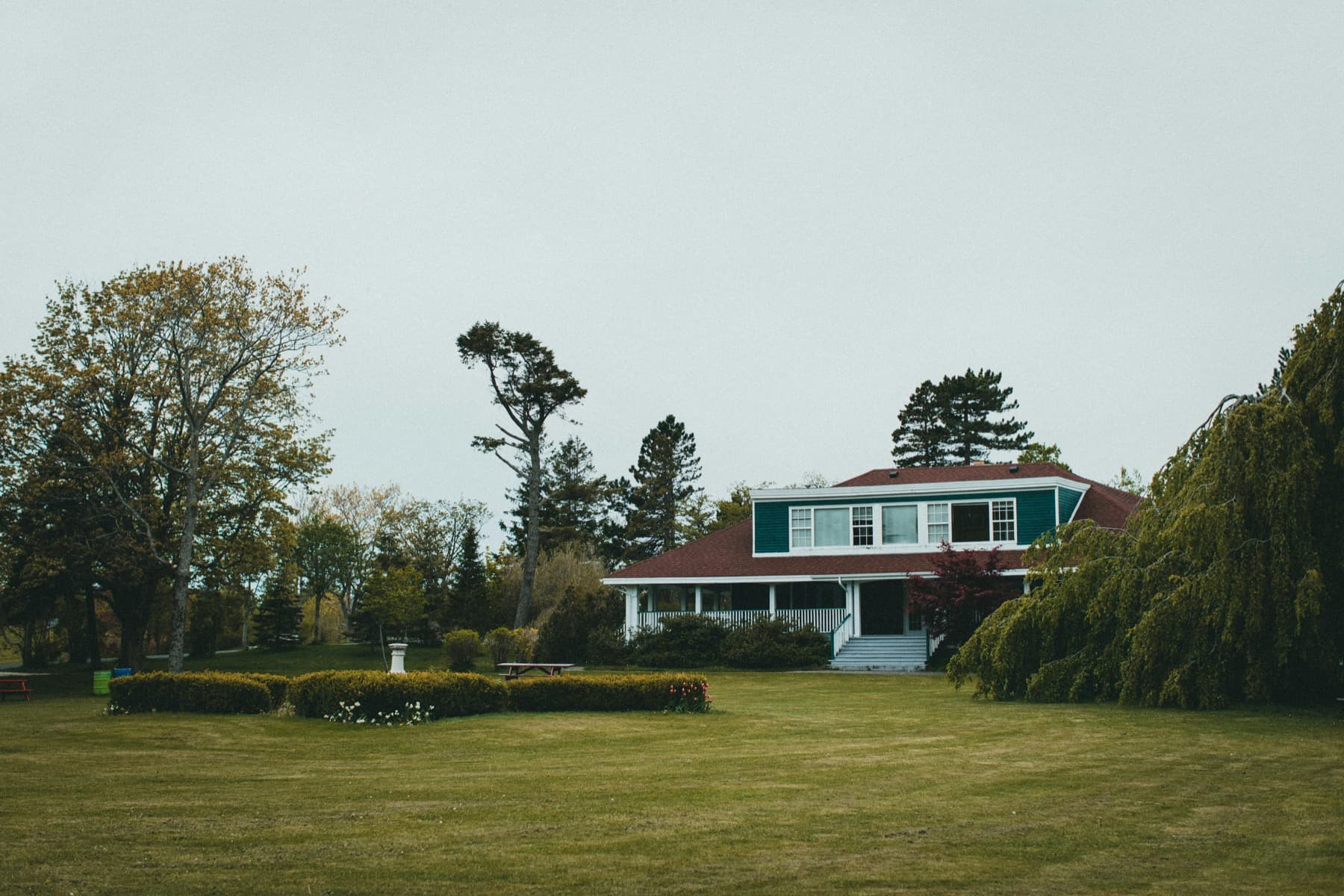 Wide front yard with a lush green lawn and landscaping.